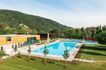 Freibad mit dem dem Becken und eine Rote Wasserrutsche